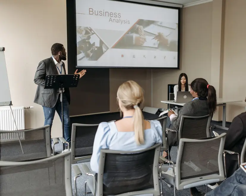 A facilitator presenting to a group in a seminar room