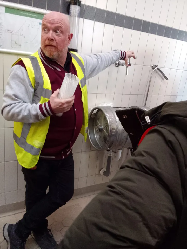 A guide explaining the brewing process during the visit to Gulpener